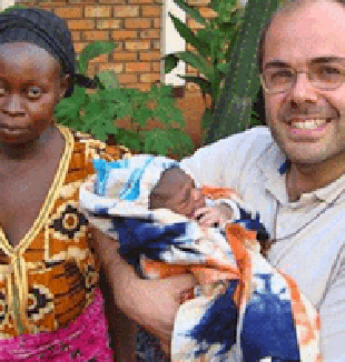 Padre Federico Trinchero con un  profugo neonato. 